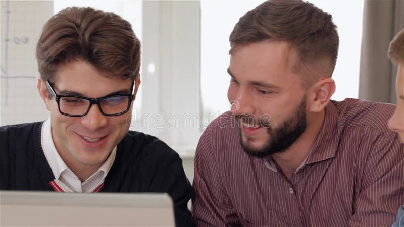 Tre män deltog i en gemensam diskussion om en bärbar dator arkivfilmer