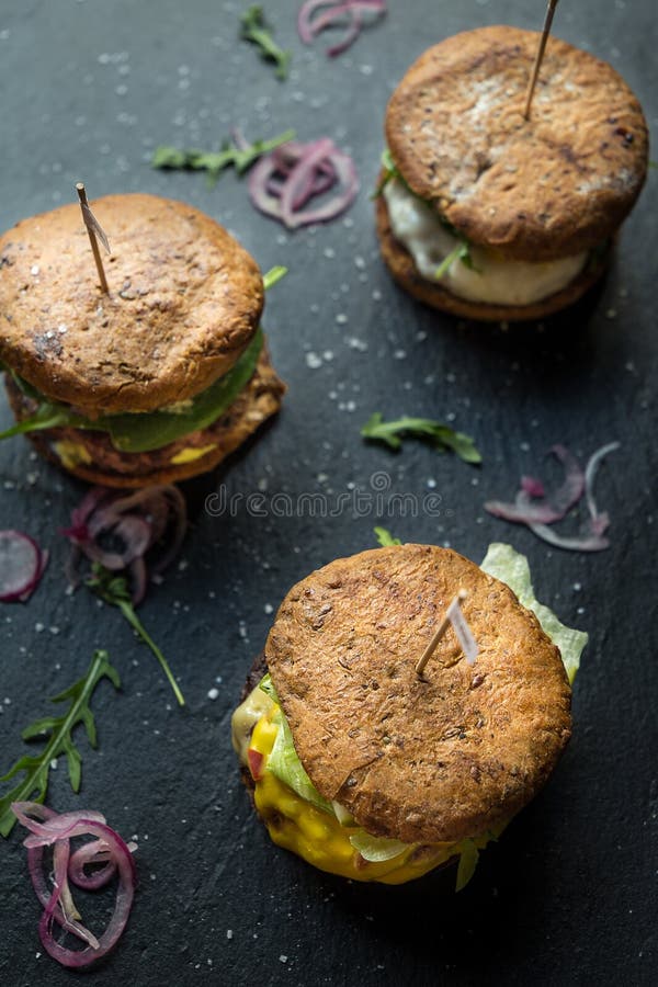 Tre olika smakliga stora hamburgare på mörk stenbakgrund, fotografering för bildbyråer Tre olika smakliga stora hamburgare på mörk stenbakgrund, fotografering för bildbyråer