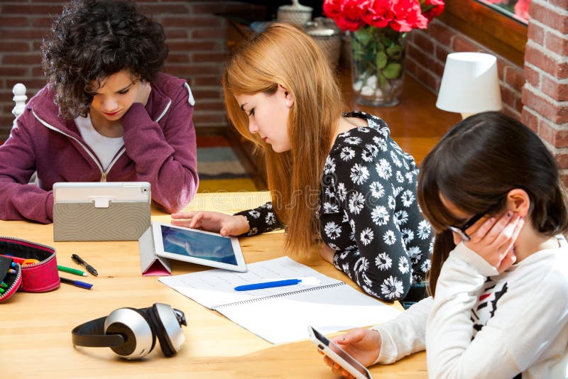 Tre studenter som arbetar på digitala apparater. arkivbilder Tre studenter som arbetar på digitala apparater. arkivbilder