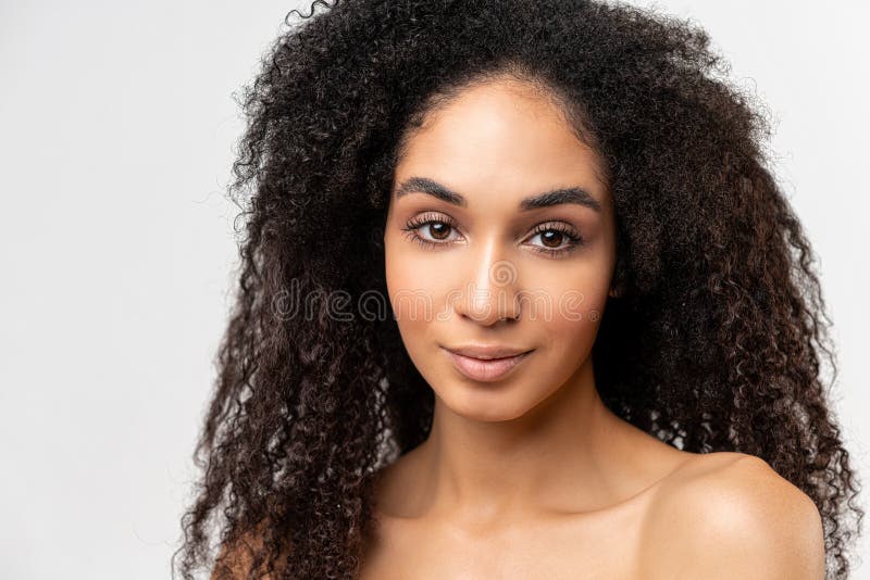 Treatment and care. Portrait view of the gorgeous curly multiracial woman with naked shoulders, looking at the camera