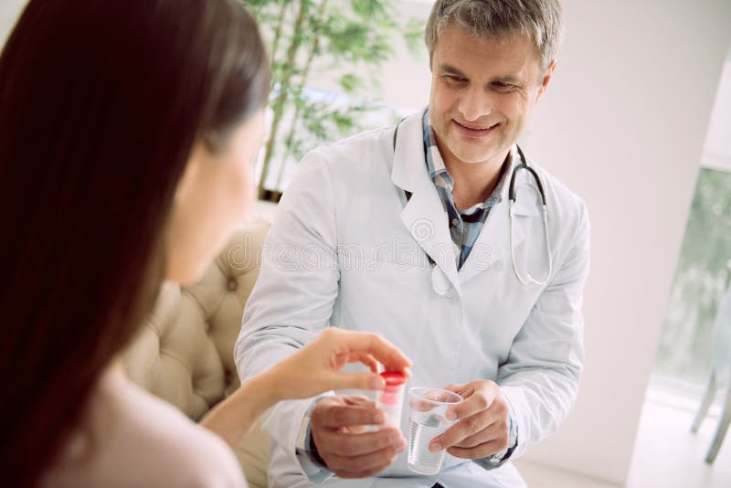 Delighted smart doctor giving medicine stock photos Delighted smart doctor giving medicine stock photos
