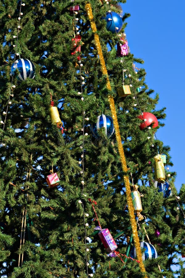 Christmas tree with toys on a background of the blue sky. Christmas tree with toys on a background of the blue sky