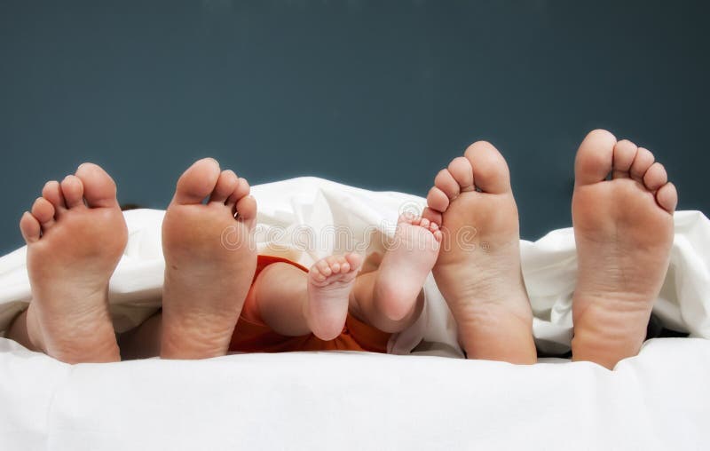 Tree pairs of legs of the happy family in bed