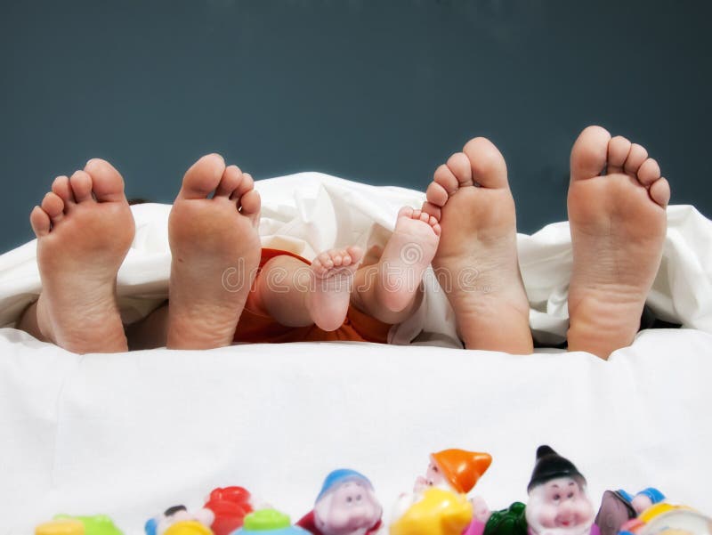 Tree pairs of legs of the happy family in bed