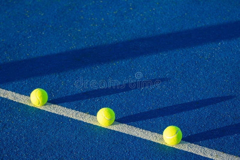 Trei mingi aliniate pe linia din spate a unui teren de tenis de padel royalty free illustration