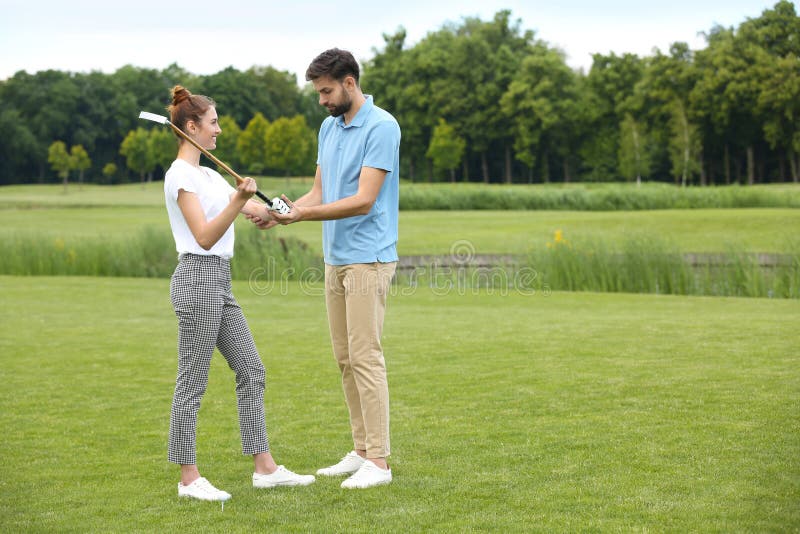 Treinador ensinando mulher a jogar golfe no curso fotos de stock Treinador ensinando mulher a jogar golfe no curso fotos de stock
