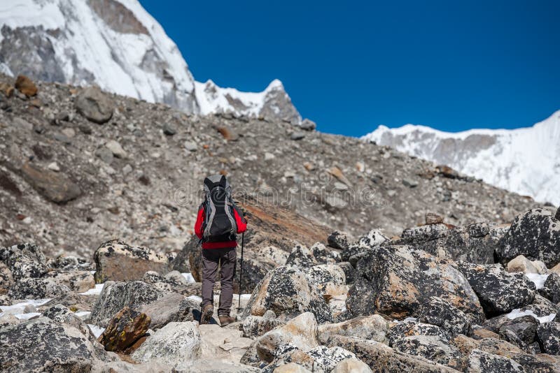 Trekker approchant la montagne de PumoRi en vallée de Khumbu sur un chemin à photographie stock libre de droits Trekker approchant la montagne de PumoRi en vallée de Khumbu sur un chemin à photographie stock libre de droits