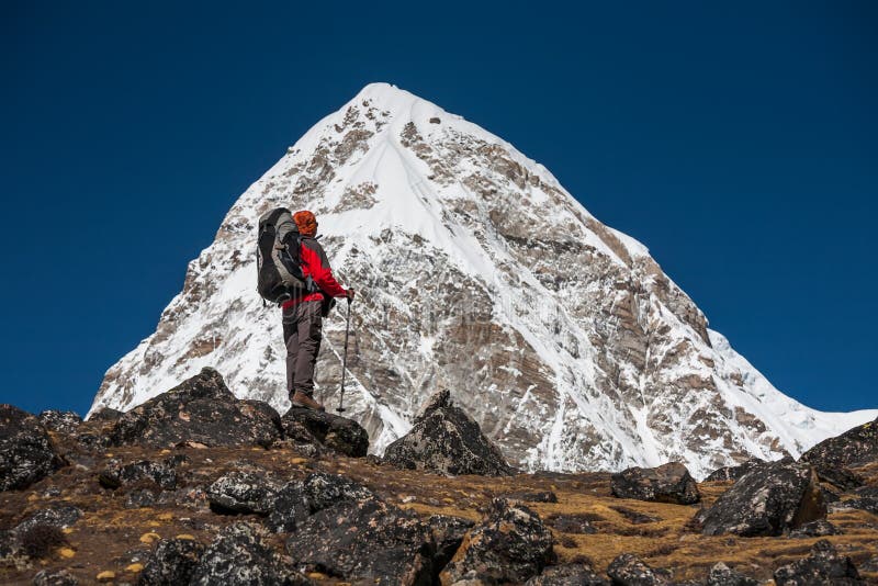 Trekker che si avvicina alla montagna di PumoRi in valle di Khumbu su un modo a immagine stock Trekker che si avvicina alla montagna di PumoRi in valle di Khumbu su un modo a immagine stock