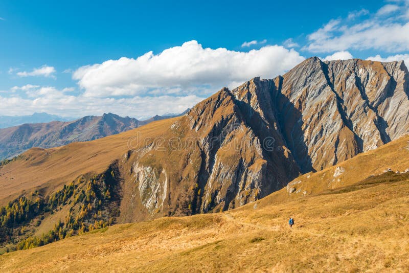 Trekker que caminha em cumes do outono com as placas magníficas da montanha em de trás, área de Grossglockner, Tirol, Áustria imagem de stock Trekker que caminha em cumes do outono com as placas magníficas da montanha em de trás, área de Grossglockner, Tirol, Áustria imagem de stock