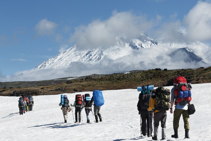 Trekking de groupe de randonneurs en montagnes sur le fond des volcans photographie stock libre de droits Trekking de groupe de randonneurs en montagnes sur le fond des volcans photographie stock libre de droits
