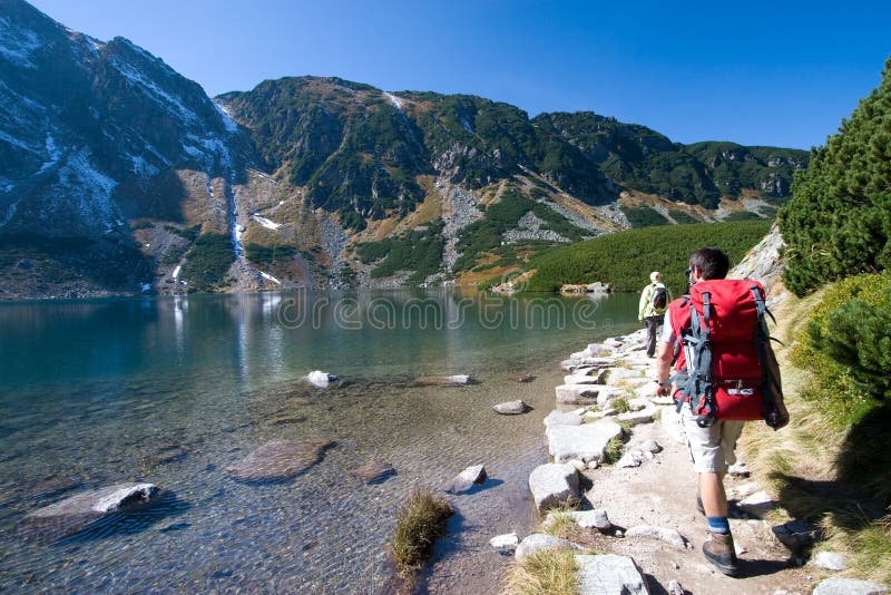 Coppia di trekking dal lato della montagna dello stagno nei Monti Tatra, in Polonia.
