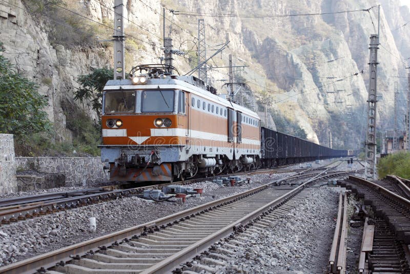 In mountain area, A freight train moving on railway line. In mountain area, A freight train moving on railway line.