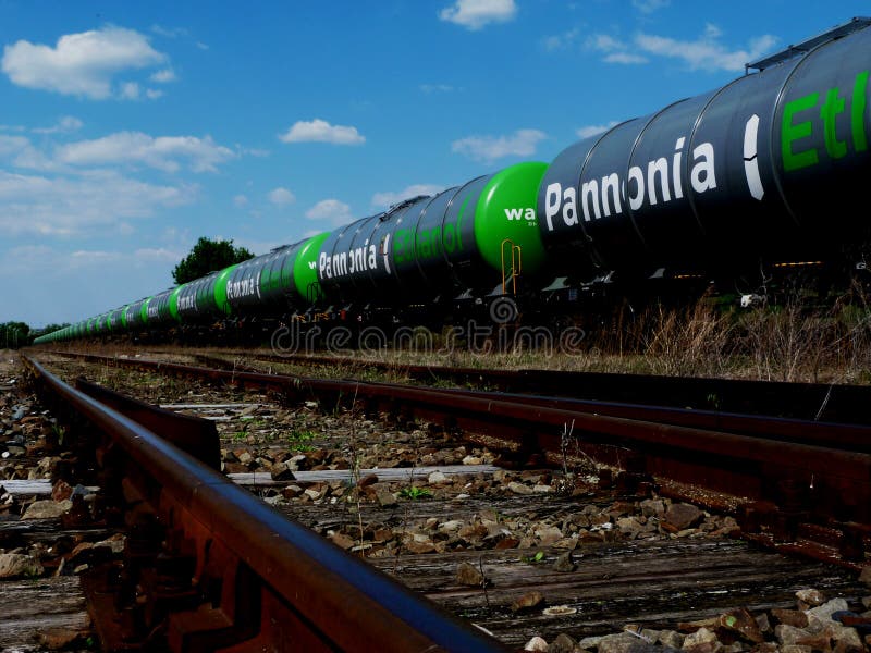 Trem de mercadorias verde de carros do petroleiro do álcool etílico sob o céu azul fotografia de stock Trem de mercadorias verde de carros do petroleiro do álcool etílico sob o céu azul fotografia de stock