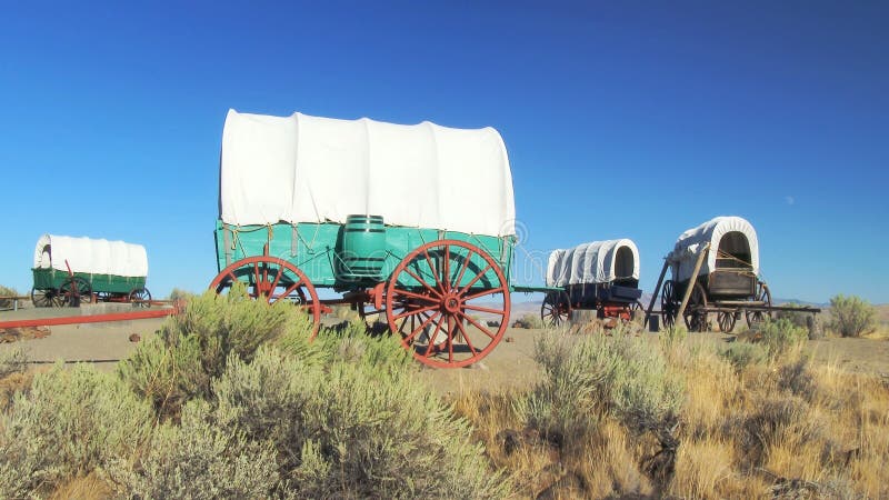 A covered wagon train forms a protective circle to camp along the Oregon Trail in eastern Oregon. A covered wagon train forms a protective circle to camp along the Oregon Trail in eastern Oregon