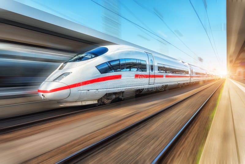 Tren de alta velocidad moderno blanco en el movimiento en el ferrocarril