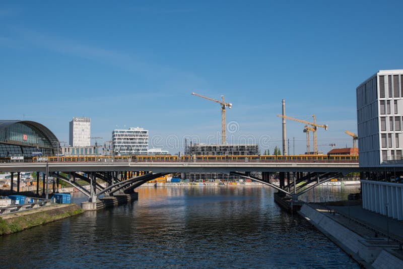 Tren local de S-bahn que pasa el puente como llega a la estación de tren central de Berlín imagen de archivo Tren local de S-bahn que pasa el puente como llega a la estación de tren central de Berlín imagen de archivo