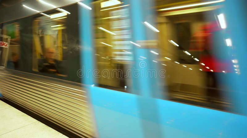 Tren subterráneo en movimiento. el metro sale de una estación de metro moderna. vagones con gente siguiendo su ruta