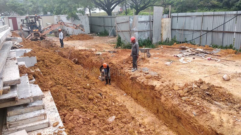 Trenches excavated at the construction site by construction workers to accommodate the utility services. stock photos