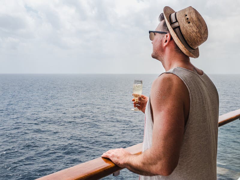 Trendig man som rymmer ett exponeringsglas av champagne arkivbild Trendig man som rymmer ett exponeringsglas av champagne arkivbild