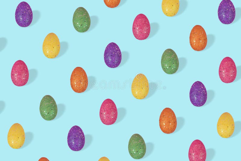 Trendy Easter pattern made of colorful eggs arranged on bright blue background stock images