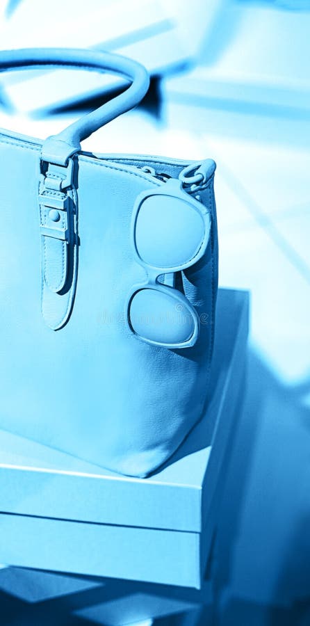 Trendy handige tas, zonnebril, schoenen op lege dozen en klassieke blauwe achtergrond stock fotografie Trendy handige tas, zonnebril, schoenen op lege dozen en klassieke blauwe achtergrond stock fotografie