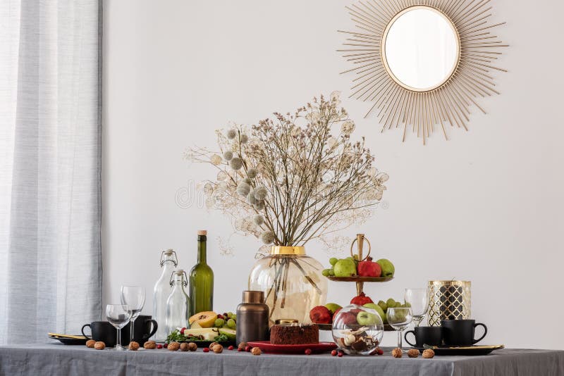 Trendy mirror in golden frame on white wall of dining room