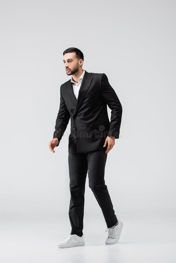 cheerful groom dancing in black suit and white sneakers isolated on white  Stock Photo - Alamy