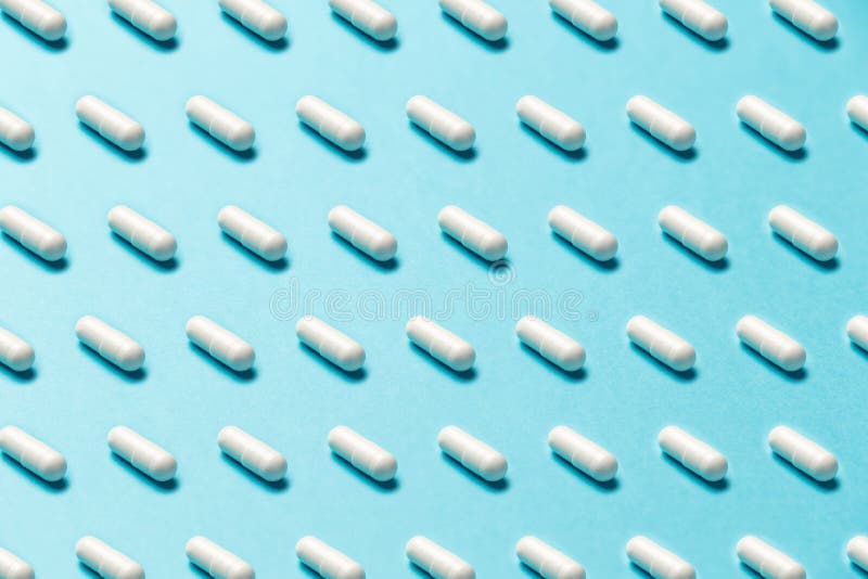 Trendy pattern made with Pharmaceutical medicine pills, tablets and capsules on bright light blue background stock image Trendy pattern made with Pharmaceutical medicine pills, tablets and capsules on bright light blue background stock image
