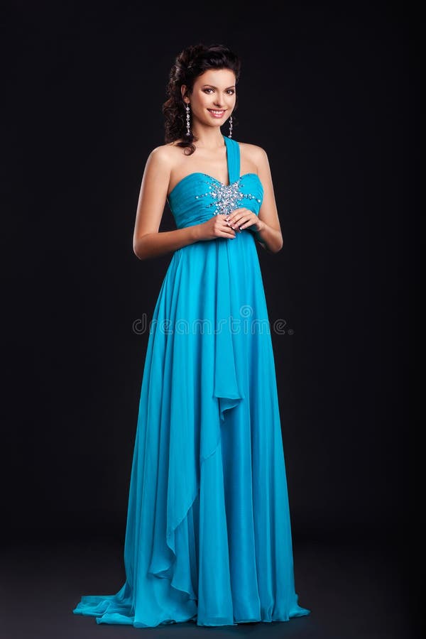 Trendy young woman in trendy blue dress smiling