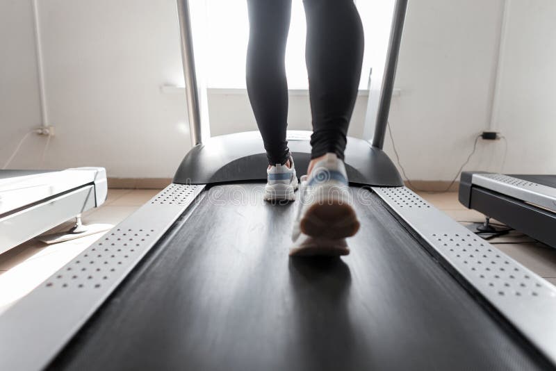 Trenes del coche de la mujer en una rueda de ardilla en un gimnasio Funcionamientos de la muchacha en una rueda de ardilla Ejerci fotografía de archivo libre de regalías Trenes del coche de la mujer en una rueda de ardilla en un gimnasio Funcionamientos de la muchacha en una rueda de ardilla Ejerci fotografía de archivo libre de regalías
