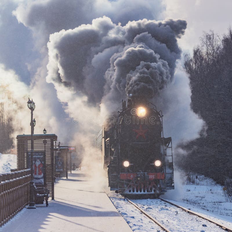 Treno arriva sulla piattaforma al mattino d'inverno fotografie stock