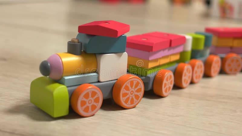 Treno giocattolo in legno colorato sul pavimento stock footage