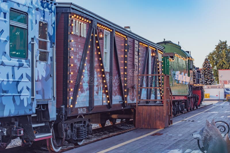 Treno a vapore per l'anno nuovo si trova vicino alla piattaforma della stazione di legno all'alba fotografie stock