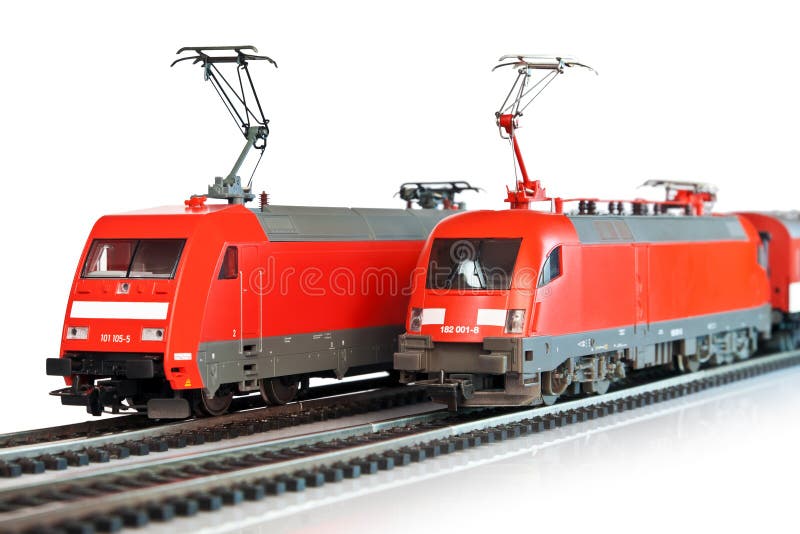 Imagem de alguns trens de brinquedo em miniatura transportando mercadorias  nos trilhos do trem próximo à vila do velho oeste