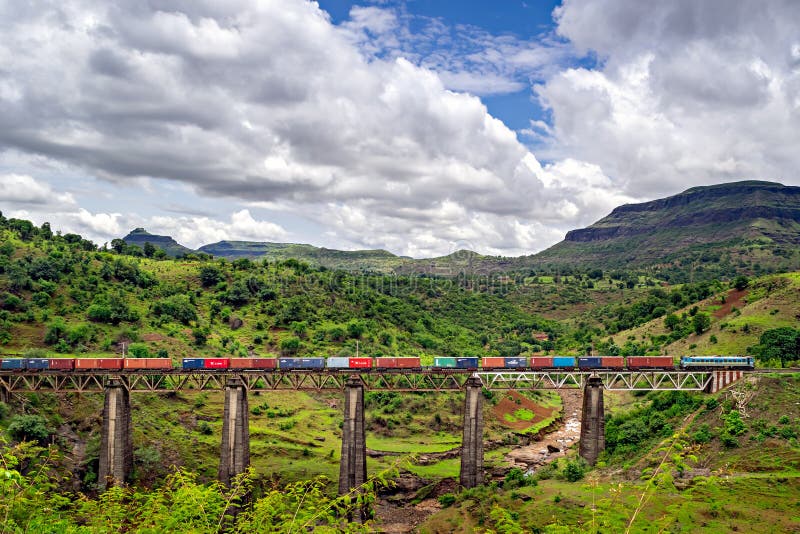 Trenulețul pentru containere colorat traversează vechiul viaduct în locul scenic royalty free stock image
