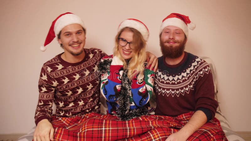 Tres adolescentes sonrientes con ropa de navidad y sombreros bailan música a cámara lenta almacen de video