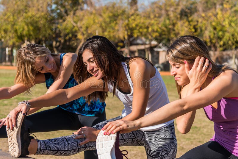 Tres amigas jóvenes trabajando en el parque, al aire libre. Concepto de deporte, salud y estilo de vida fotos de archivo libres de regalías Tres amigas jóvenes trabajando en el parque, al aire libre. Concepto de deporte, salud y estilo de vida fotos de archivo libres de regalías