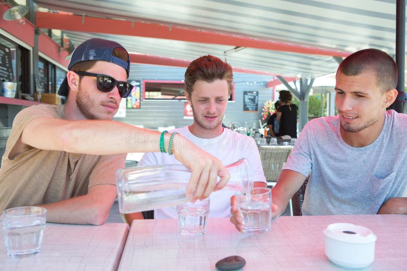 Tres amigos felices beben agua para calmar su sed fotos de archivo libres de regalías