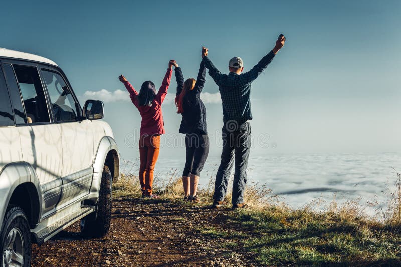 Tres amigos se unieron a las manos y aumentaron sus manos para arriba, disfrutando de la vista de al aire libre Concepto del viaj foto de archivo libre de regalías Tres amigos se unieron a las manos y aumentaron sus manos para arriba, disfrutando de la vista de al aire libre Concepto del viaj foto de archivo libre de regalías