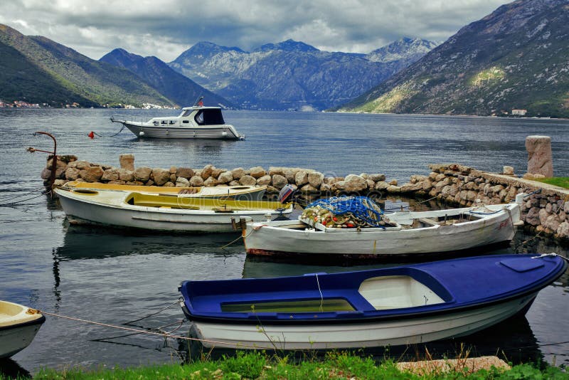 Tres barcos de pesca amarrados en peque?o muelle en la bah?a, Montenegro fotografía de archivo libre de regalías Tres barcos de pesca amarrados en peque?o muelle en la bah?a, Montenegro fotografía de archivo libre de regalías