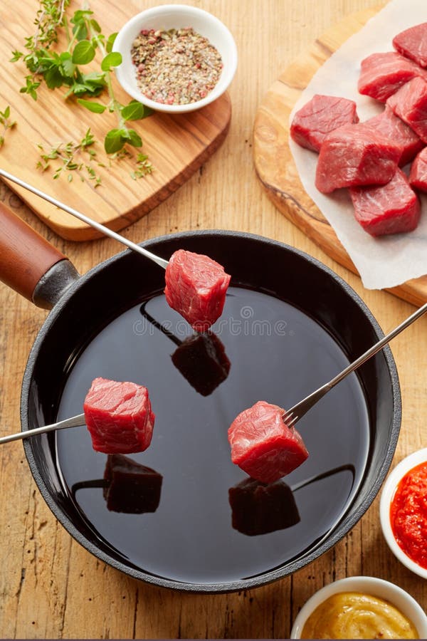 Tres bifurcaciones de la 'fondue' con los cubos de la carne cruda fotografía de archivo Tres bifurcaciones de la 'fondue' con los cubos de la carne cruda fotografía de archivo