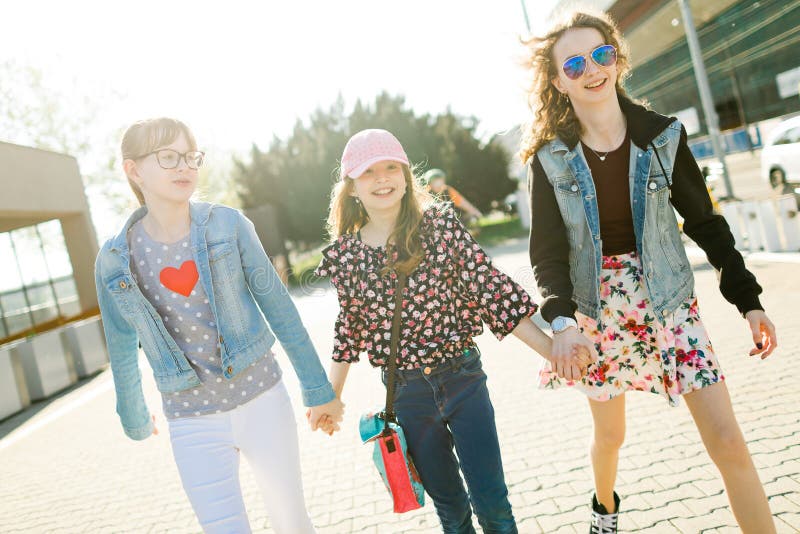 Tres chicas j?venes que caminan en las calles de la ciudad imagen de archivo libre de regalías Tres chicas j?venes que caminan en las calles de la ciudad imagen de archivo libre de regalías