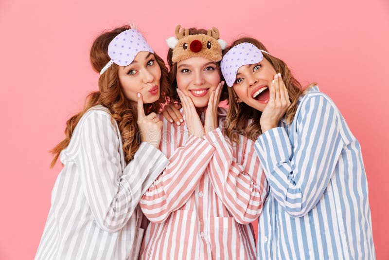 Tres chicas jóvenes hermosas 20s que llevan pijamas rayados coloridos foto de archivo libre de regalías Tres chicas jóvenes hermosas 20s que llevan pijamas rayados coloridos foto de archivo libre de regalías