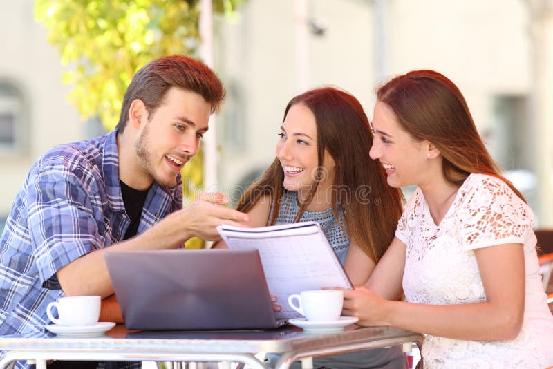 Tres estudiantes que estudian y que aprenden en una cafetería imágenes de archivo libres de regalías
