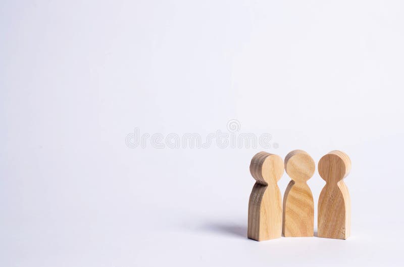 Tres figuras de madera de la gente se unen en un backgro blanco. Tres figuras de madera de la gente se unen en un fondo blanco Abstracción de una reunión, discusión, conversación La gente discute noticias y rumores