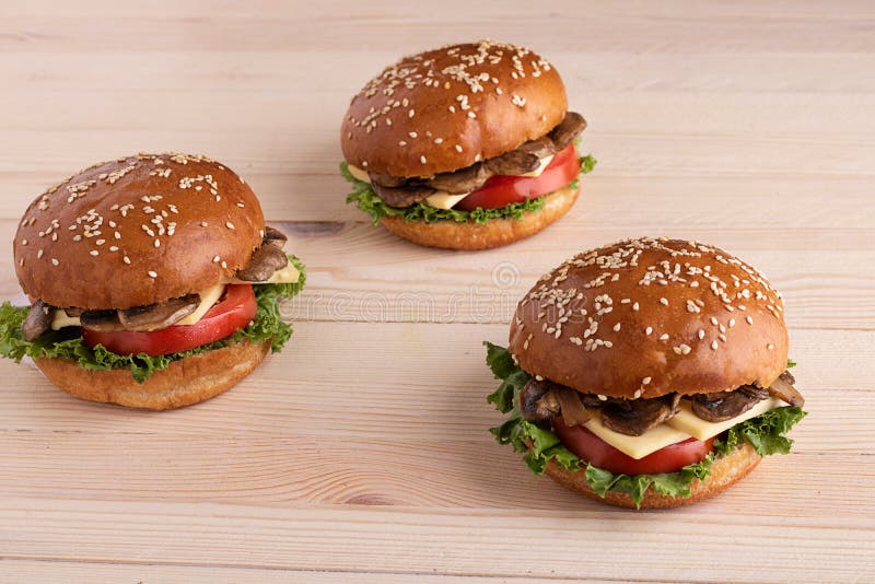 Tres hamburguesas de la seta en fondo de madera foto de archivo Tres hamburguesas de la seta en fondo de madera foto de archivo