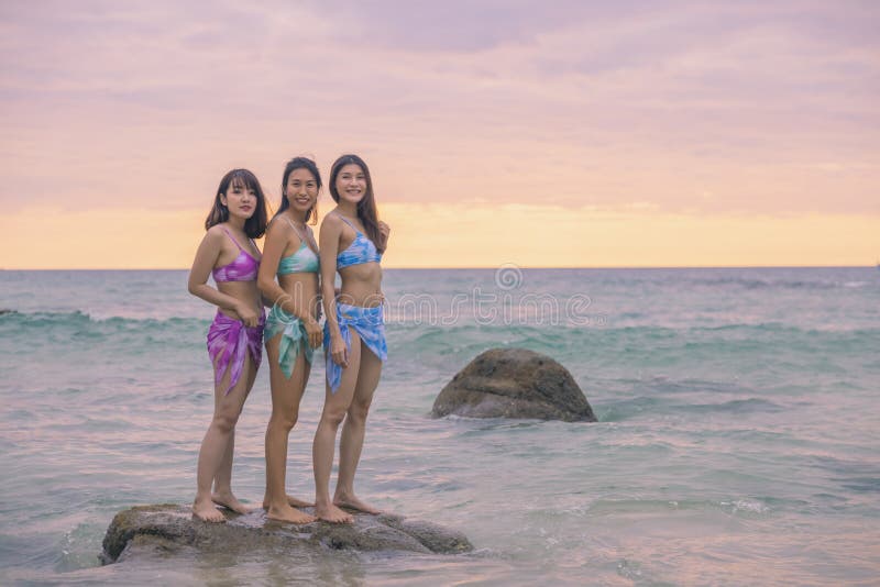 Tres Jóvenes Amigas Felizmente Este Bikini Azul Púrpura Verde De Pie En Las Rocas En Nai Thon Beach Phuket Tailandia. Imagen de archivo - Imagen de manera, sonrisa: 213324737