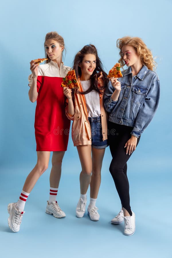 Tres Jóvenes Atractivas Mujeres Con Atuendos Retro Estilo De Moda De Los Años 90 Comiendo Pizza Aislado Sobre Fondo De Estudio Azu Foto archivo - Imagen de peinado, glamour: 225068626