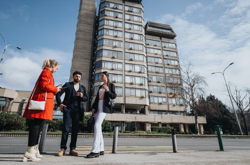 Young adults in professional attire having a conversation outside a modern office building, portraying a casual business atmosphere. Young adults in professional attire having a conversation outside a modern office building, portraying a casual business atmosphere.