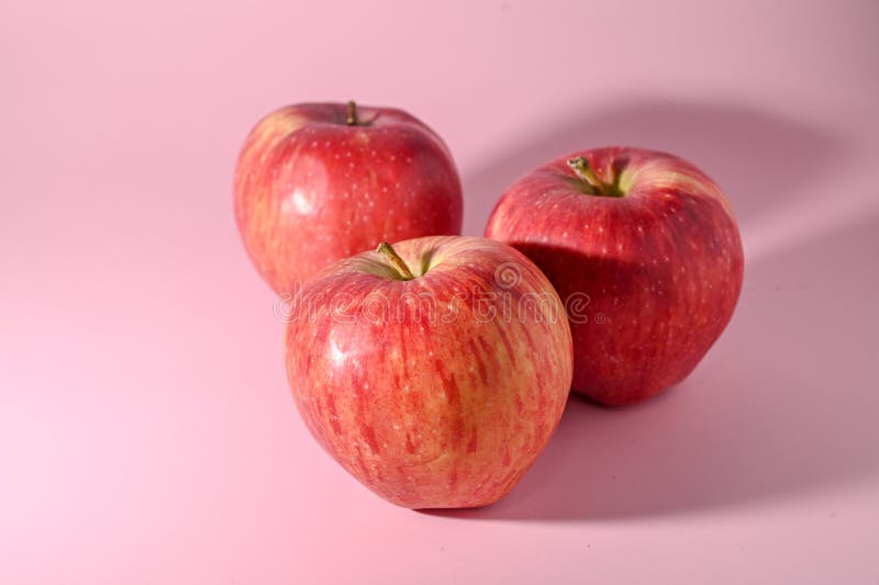 three red apples on a pink background 2. three red apples on a pink background 2